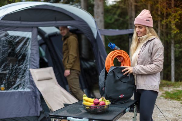 Una mujer saca el alargador CEE de camping de su bolsa de transporte